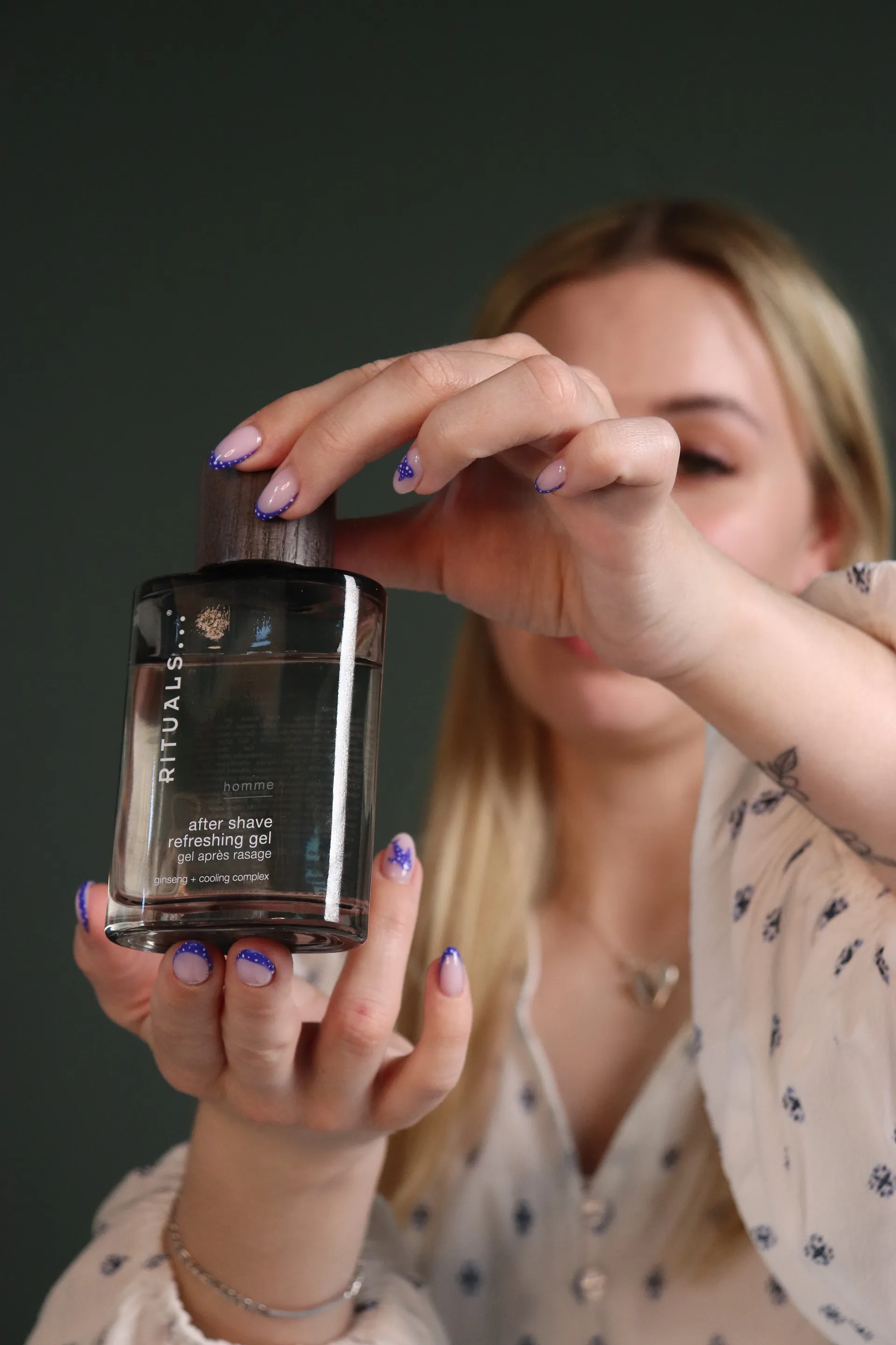 Nærbillede af to hænder der åbner en after shave-gel under et live show