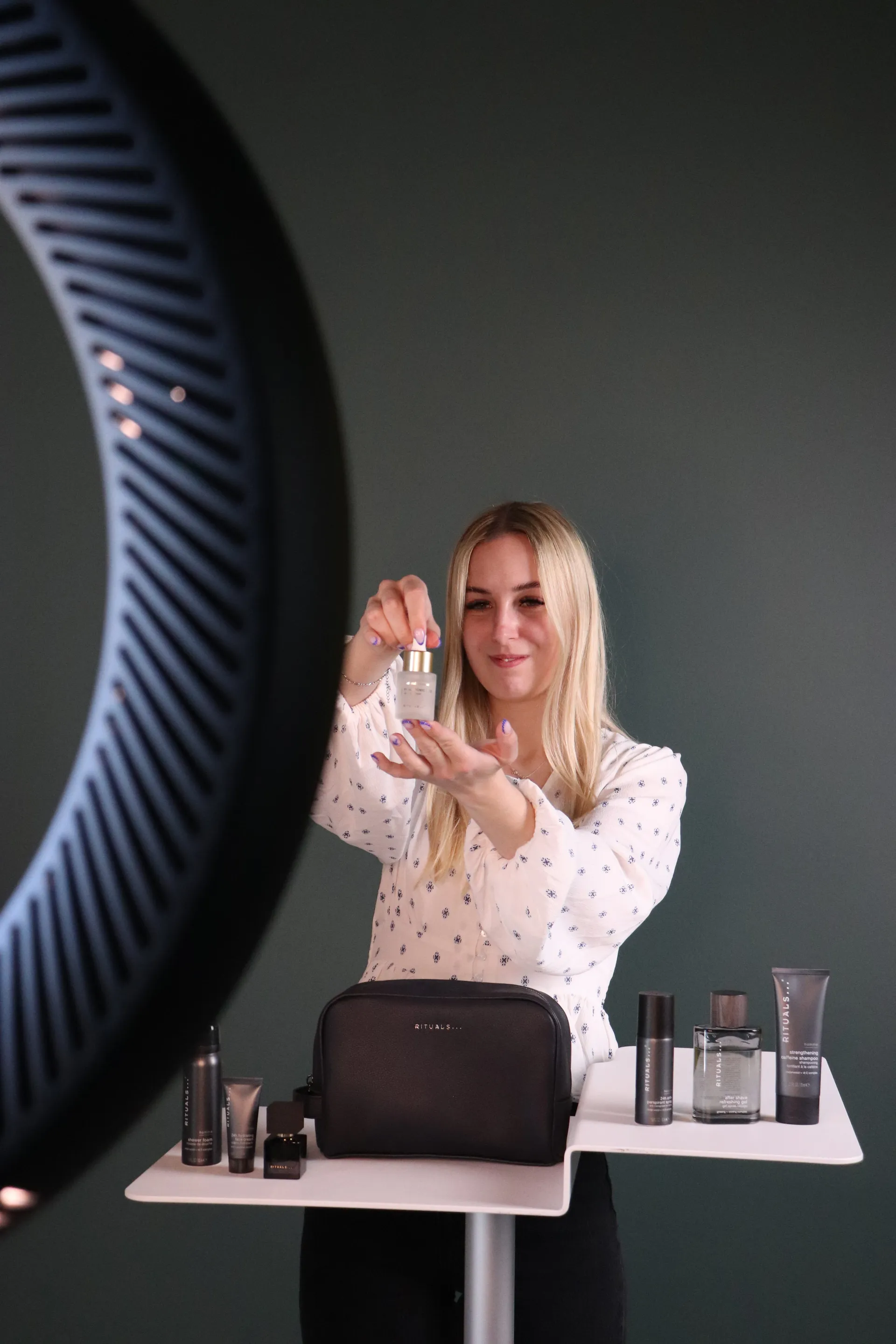 Vært præsenterer et produkt tæt på kameraet i et gennemarbejdet setup