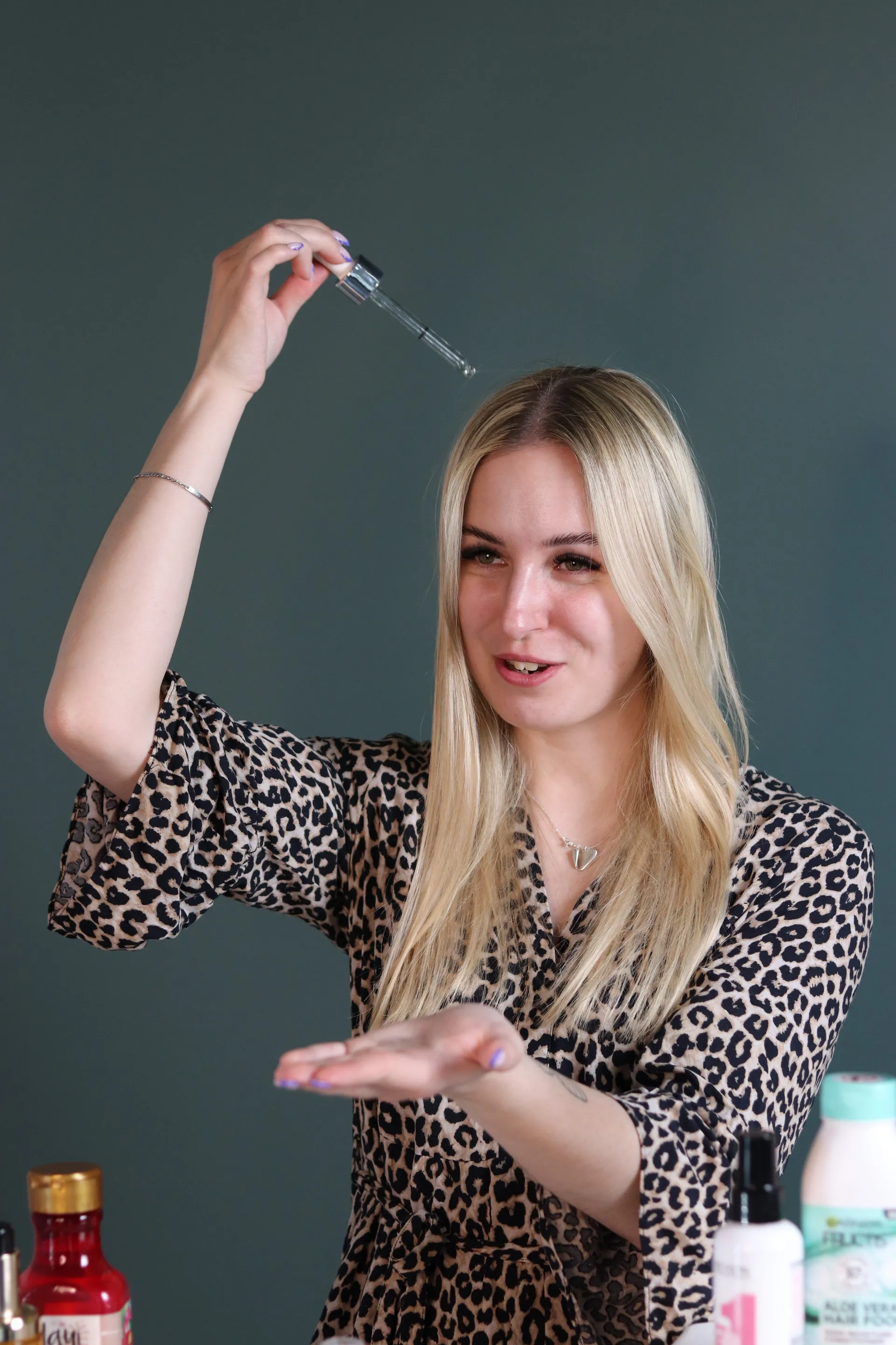Butiksindehaver viser en hårserum med pipette frem foran kameraet