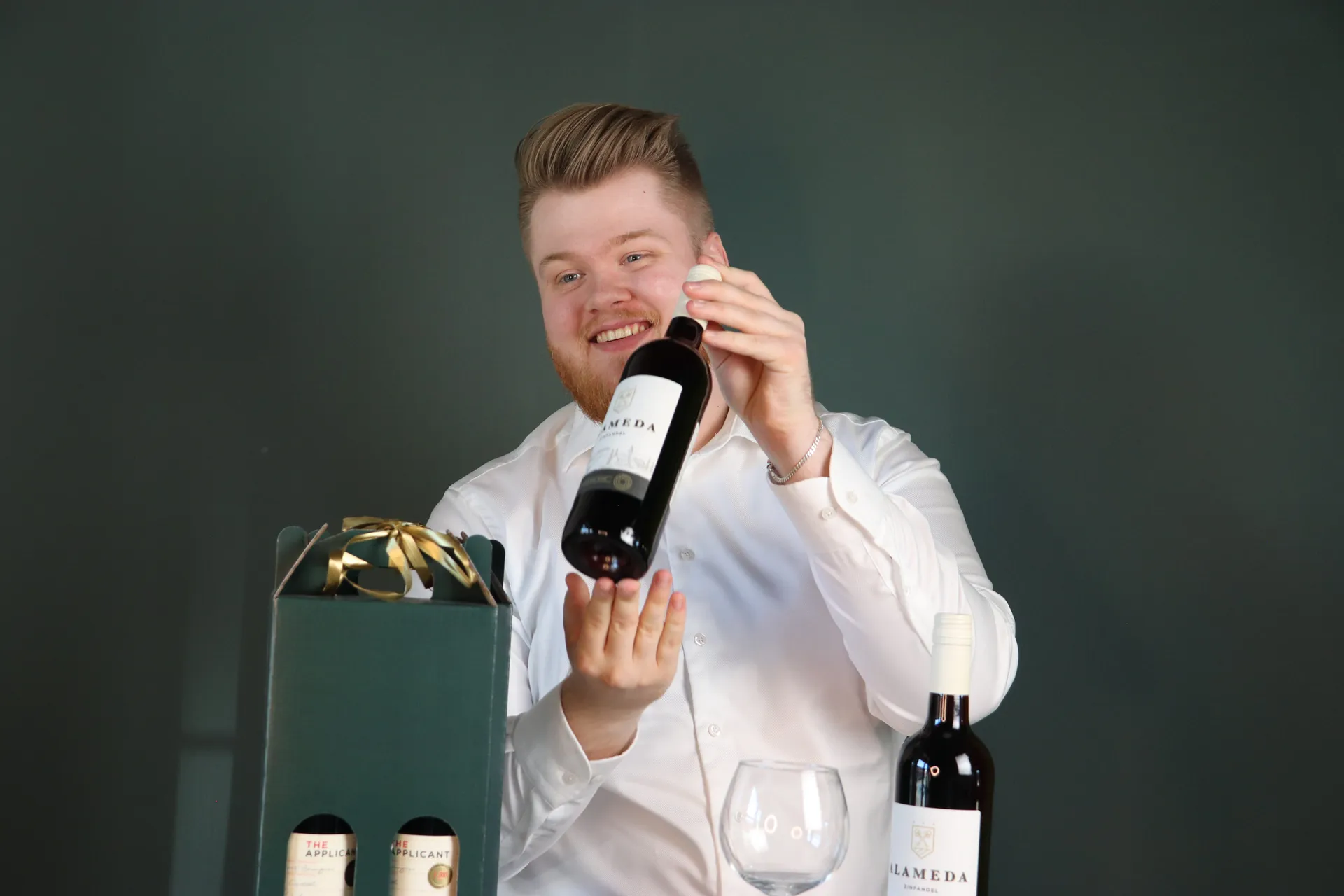 Vinhandler smiler mens han åbner en vinflaske
