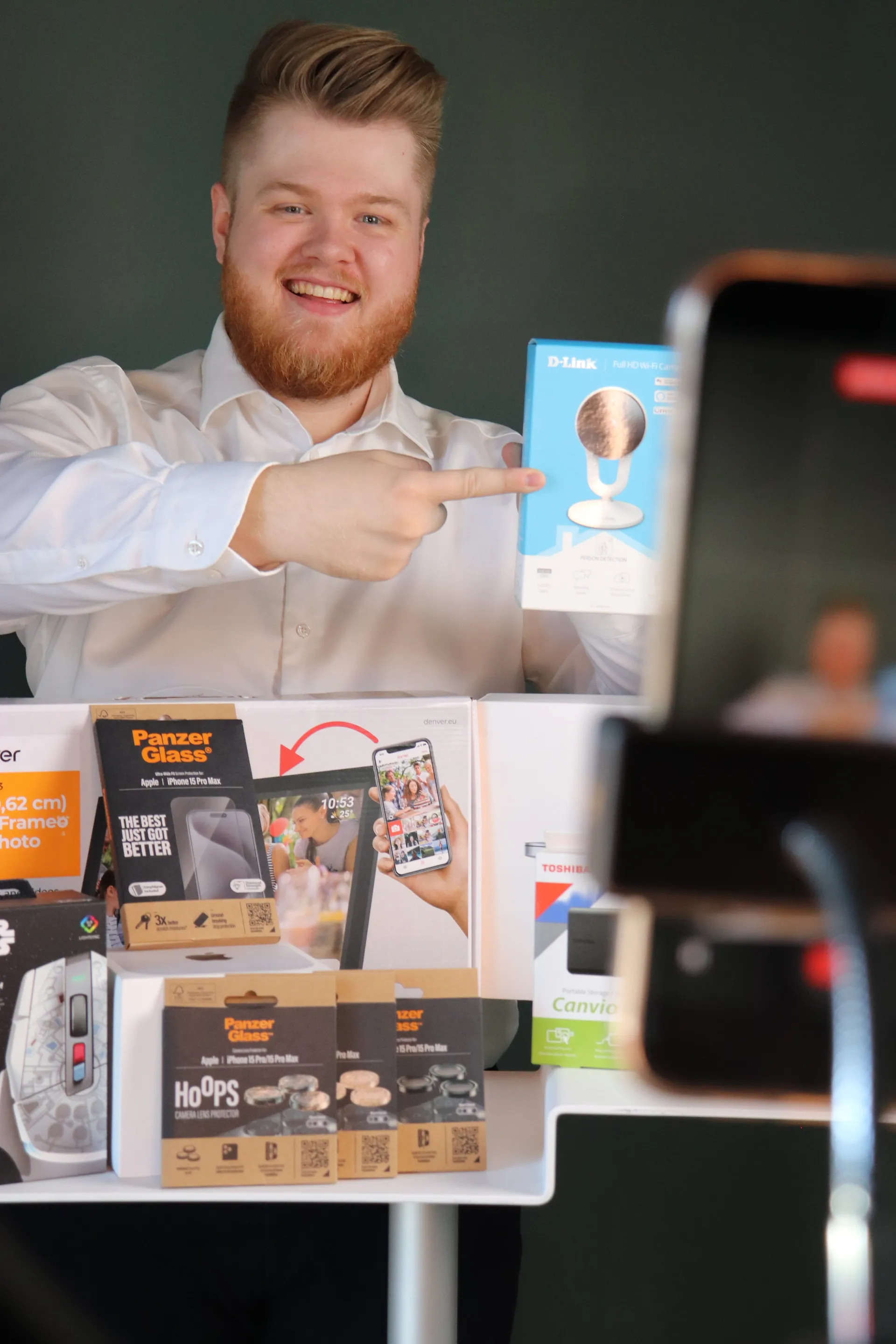 Vært peger på en D-Link wifi-kamera-æske med fuld produktopstilling på bordet